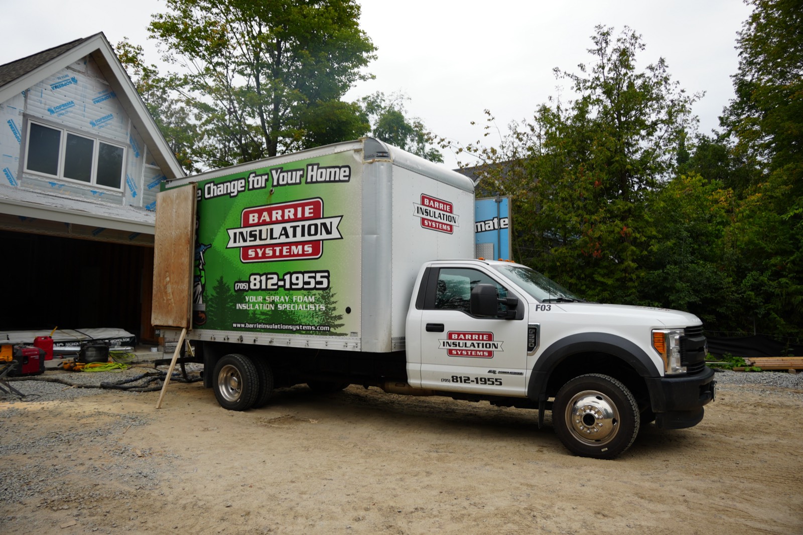 Barrie Insulation Systems box truck parked at a custom home
