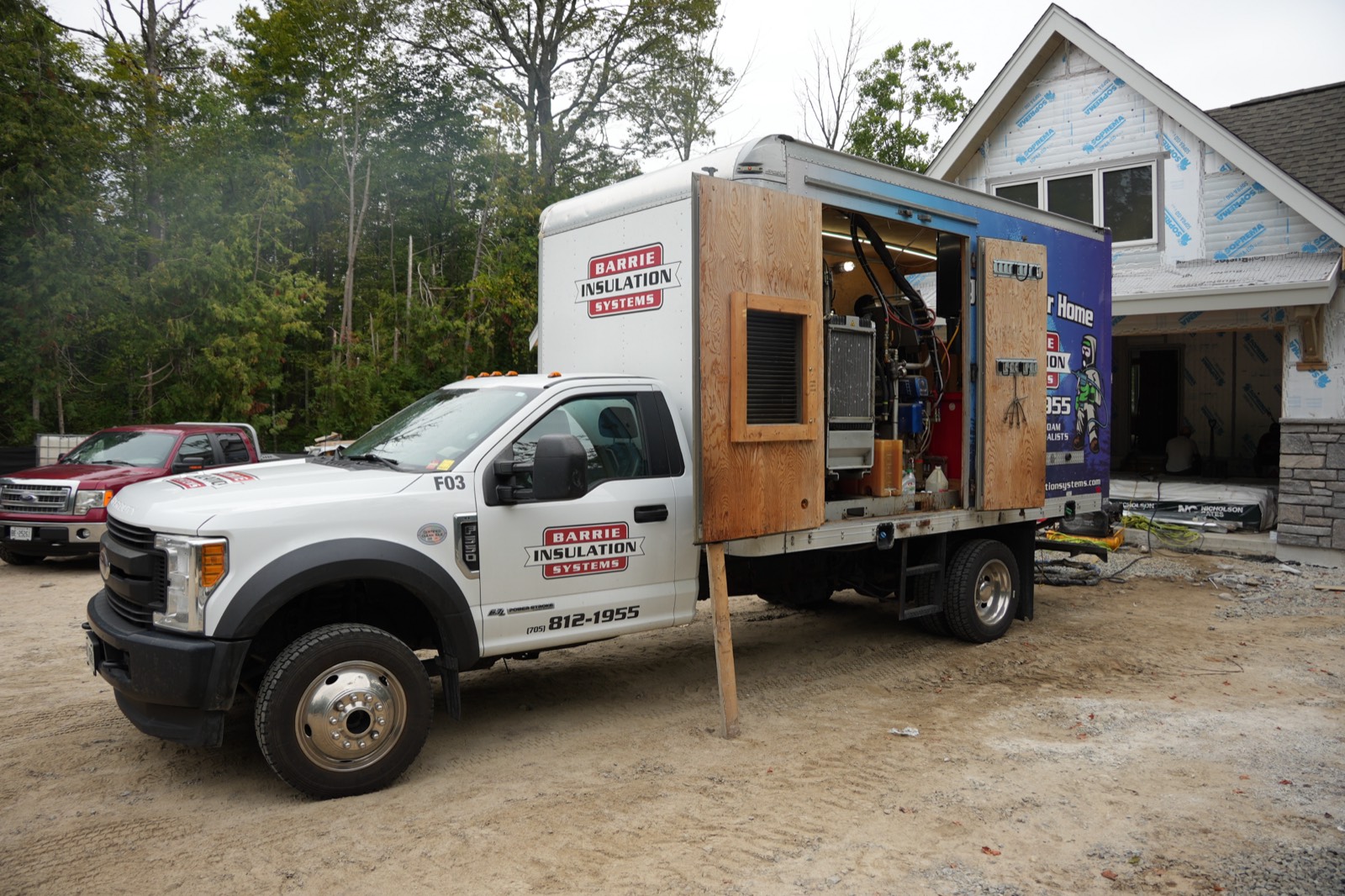 Barrie Insulation Systems truck with the spray foam rig open at a new build